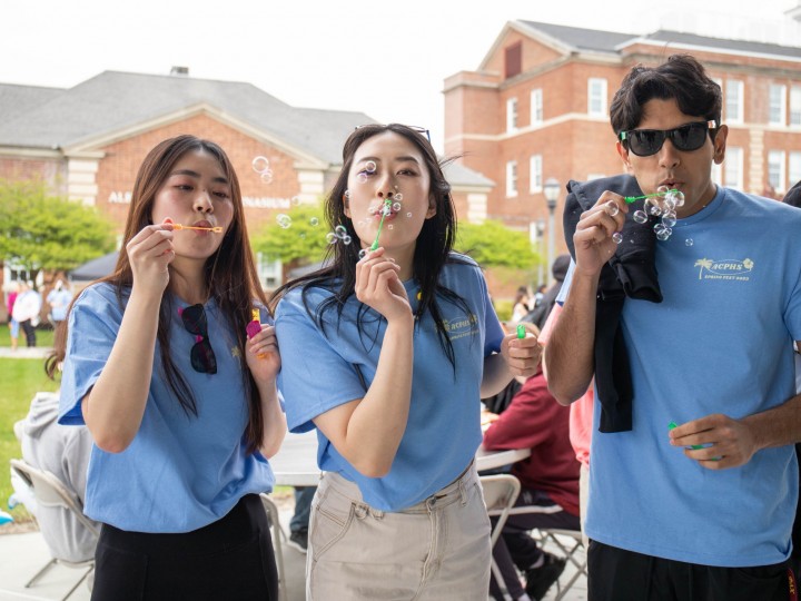 Three students blowing bubbles