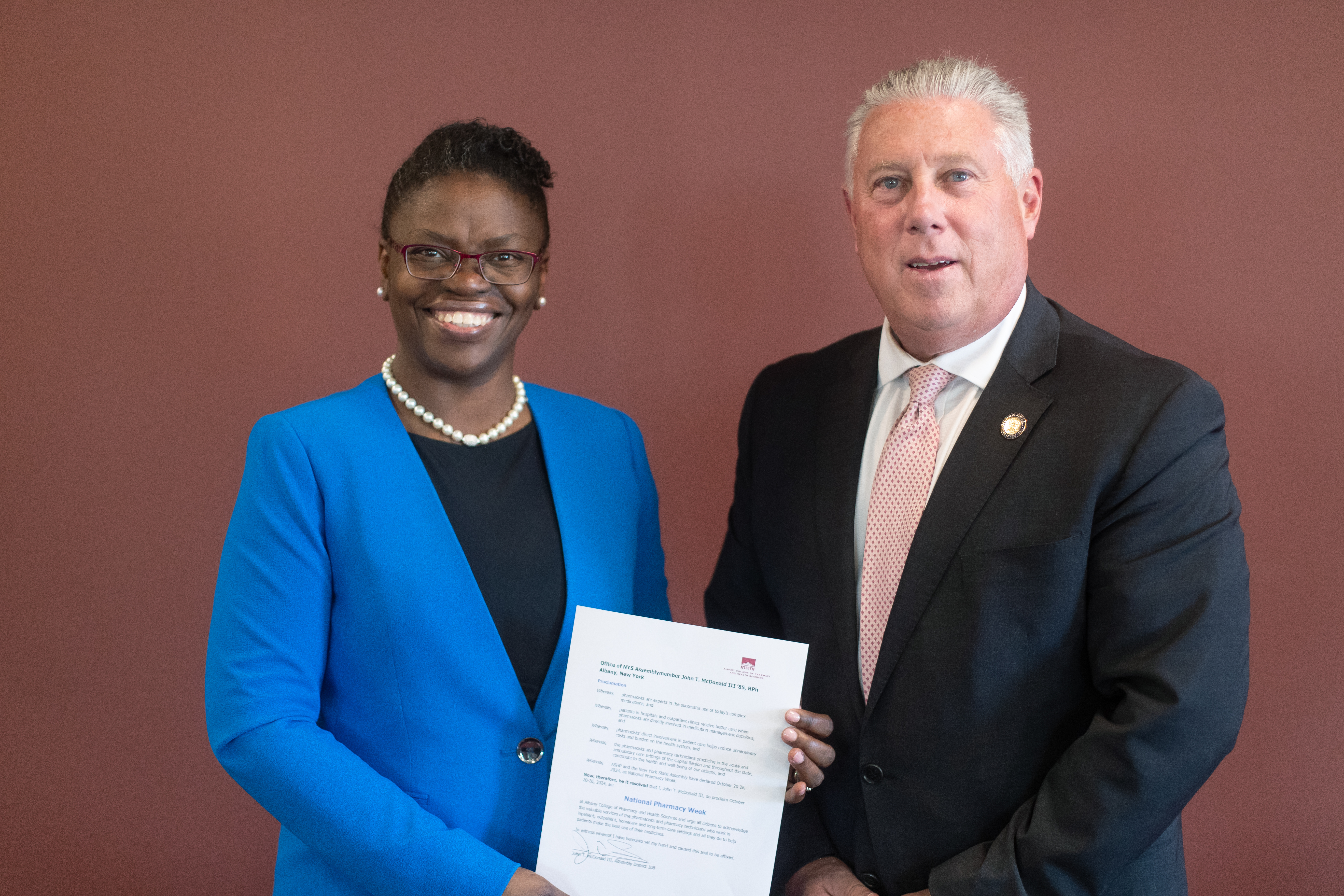 ACPHS President Toyin Tofade and state Assemblyman John T. McDonald III '85 with signed proclamation 