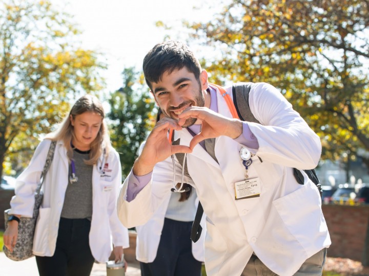 A student puts togther his hands in a heart shape